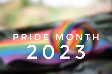 Pride Month 2023 with blurred rainbow wristband and flag background, concept for LGBT community celebrations in pride month, June, around the world.