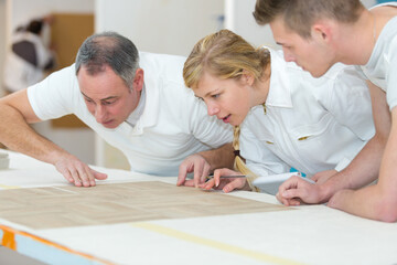 Fototapeta premium teacher carpenter with woman and man in workshop