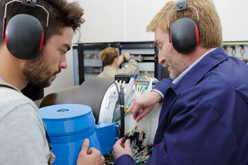 apprentice engineer being shown cable connections