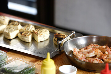 halloumi cheese on a steel tray. an ingredient for the saganaki dish.