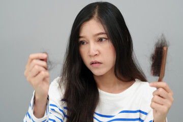 stressed woman having hair loss problem with hairbrush