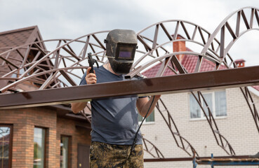 Naklejka premium A worker welds metal at a construction site.