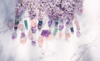 minerals and lilac flowers on marble background. gemstones for esoteric spiritual practice. Healing magic Crystal Ritual, Witchcraft for Relax, harmony, Good energy. flat lay. template for design