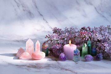 Gemstones set, candle, lilac flowers on marble background. gemstones for Healing Crystal Ritual,...
