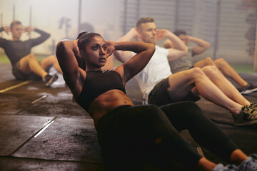 Fit young woman doing sit-ups during a gym exercise class