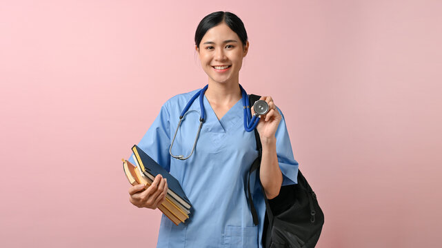 Young beautiful Asian medical student smiling to the camera while holding a bag and books