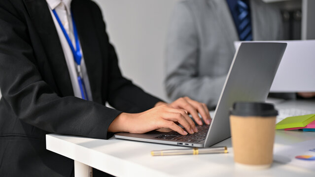 Cropped image of a businesswoman using her laptop computer during the meeting