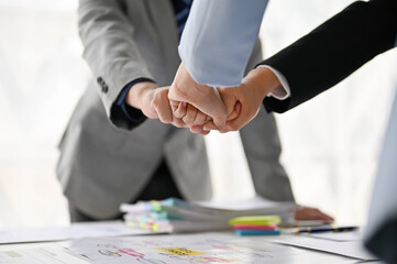 Close-up image of diverse businesspeople bumping their fists together