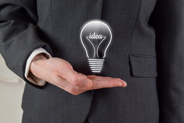 Business Idea Concept - Closeup of Lightbulb Over Business Woman's Hand