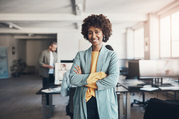 Young businesswoman smiling in an office with colleagues in the background