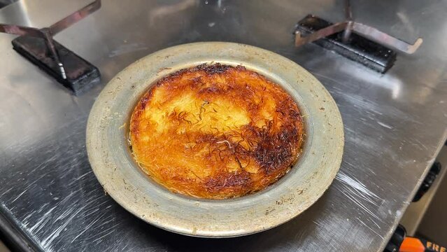 Kunefe dessert. Traditional Turkish dessert kunefe in the copper plate. Kanafeh concept with cheese and pistachio