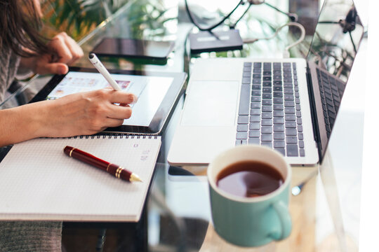 Freelancer using tablet PC at desk in home office