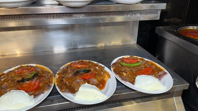 Iskender kebab. Kebab prepared with butter, bread, tomato sauce, and meat doner. Iskender kebab prepared on the counter