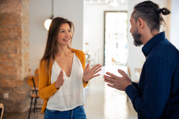 Smiling woman gesturing and talking to man at cafe