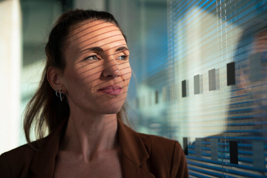 Thoughtful businesswoman near wall at office