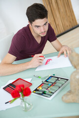man painting brush watercolors on paper
