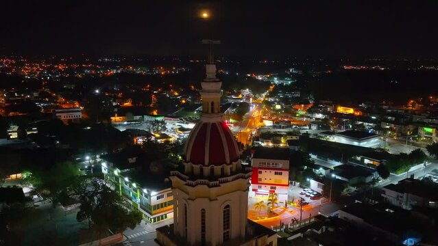 Sacred Heart of Jesus Church or Iglesia Sagrado Coraz&oacute;n De Jesus at night with moon in dark sky, Moca in Dominican Republic