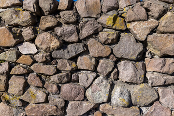 part of an old fence made of a large number of stones