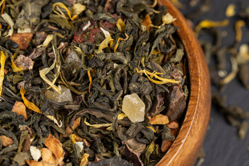A large amount of dry green tea with pieces of fruit
