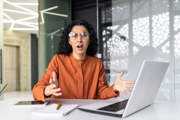 Fototapeta na wymiar Frustrated and sad woman inside office looking at camera, businesswoman unhappy with achievement results working at desk using laptop at work.