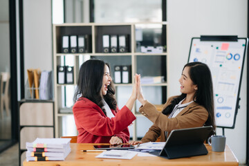 Obraz premium Young Asian business team creative businesspeople coworker, teamwork celebrating achievement and in planning design in office.