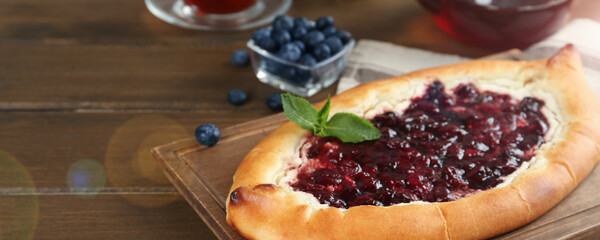 Delicious sweet cottage cheese pastry with jam on wooden table, banner design. Space for text