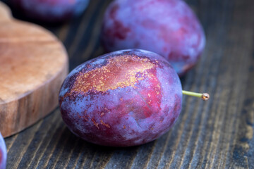 Ripe plums of dark color on the table