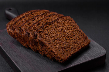 Delicious fresh brown bread with grains and seeds sliced on a wooden cutting board