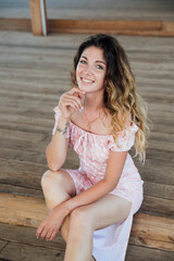 beautiful cheerful woman sitting on a wooden floor