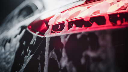 Brake Light on a Modern Black Car. Close Up Aesthetic Photo of a Vehicle in a Car Wash. Macro Shot...