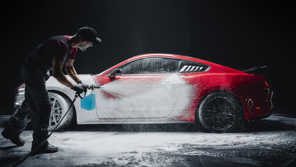 Car Wash Detailer Spraying Smart Foam to Clean the Exterior of a Tuned Red Sports Coupe at a...