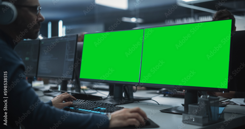 Fototapete Close Up of a Software Developer Working on a Desktop Computer with Green Screen Mock Up Display. Specialist Typing on Keyboard, Coding and Implementing a New Technical Feature, Working in an Agency