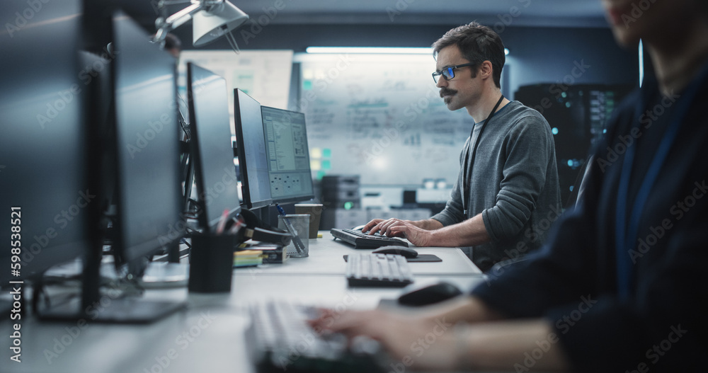 Poster Portrait of a Thoughtful Engineer Working on Desktop Computer in a Technological Office Environment. Research and Development Department Writing Software Code for an Innovative Internet Project