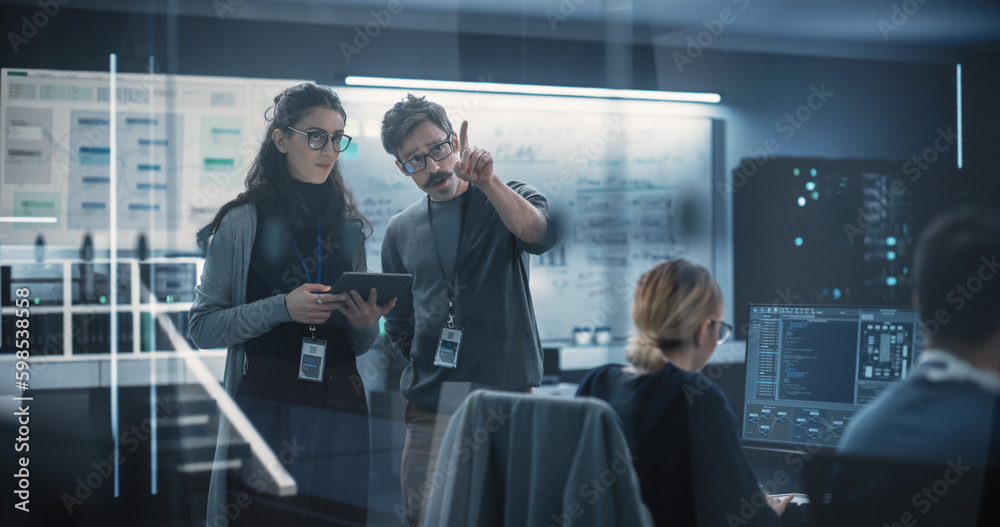 Poster Multicultural Chief Technology Officer Talking to Software Developer, Discussing Neural Network Updates in High Tech Research and Development Facility. Professional Computer Specialists at Work