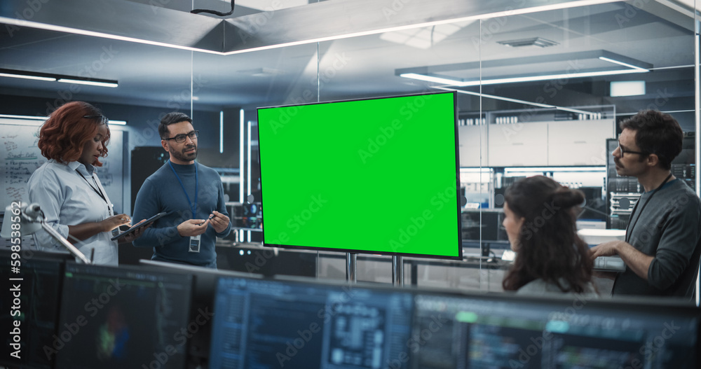 Poster Group of Multiethnic Software Developers Having a Meeting in a Conference Room with Green Screen Mock Up Display. Specialists Brainstorming New Ideas and Solving Problems in the Office