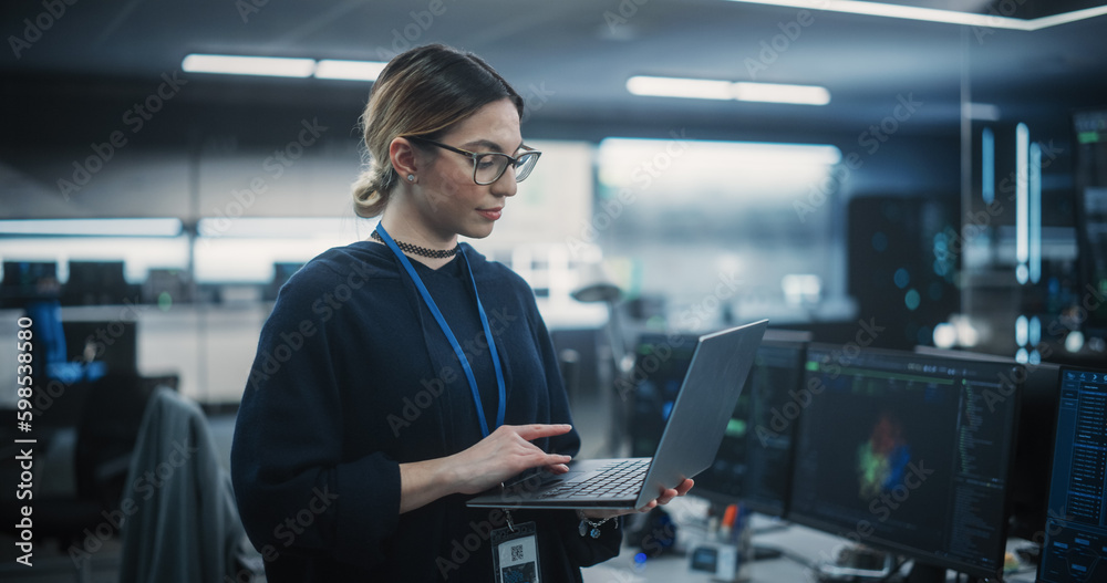 Leinwandbilder Portrait of a Multiethnic QA Engineer Working on Finding and Fixing Bugs in a Product or Software Before the Launch. Female Using Laptop in a Room with Big Green Screen Mock Up Display