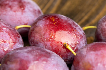 Ripe plums of dark color on the table