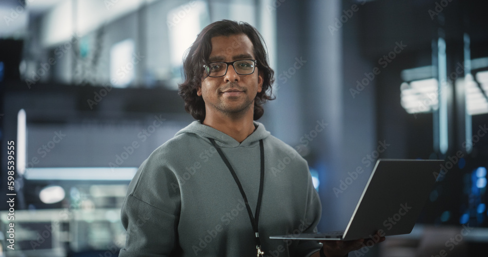 Aufkleber Young Indian Software Engineer Using Laptop Computer in Data Center, Looking at Camera. Successful Information Technology Manager Standing in a Room in a Tech Office