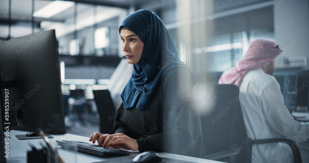 Poster Portrait of a Smart Focused Middle Eastern Engineer Working on Computer in a Technological Corporate Office. Young Arab Woman in Hijab Developing Software for an Innovative Internet Service Provider