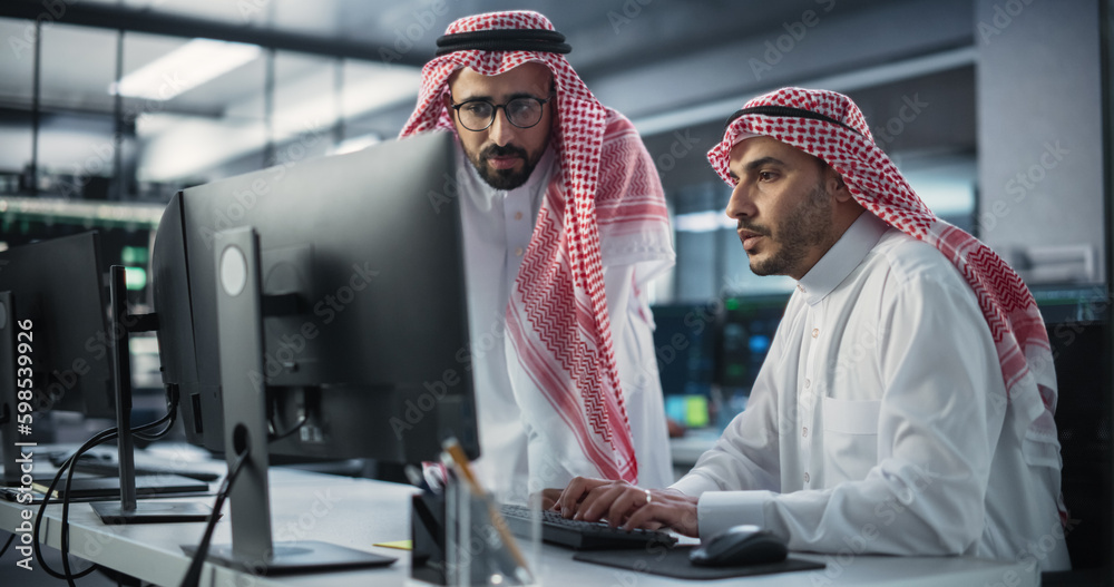 Aufkleber Two Multiethnic Arab Colleagues Having a Conversation While Busy Working on a Software Development Project. Engineer Talking with a Middle Eastern Project Manager. Teamwork in Technology Laboratory