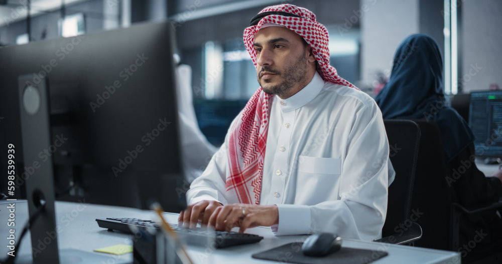 Poster Arab System Administrator Working in a Research E-Business Facility on a Desktop Computer. Focused Middle Eastern Software Developer Updating Server System Database. Gulf Man At Work in Office