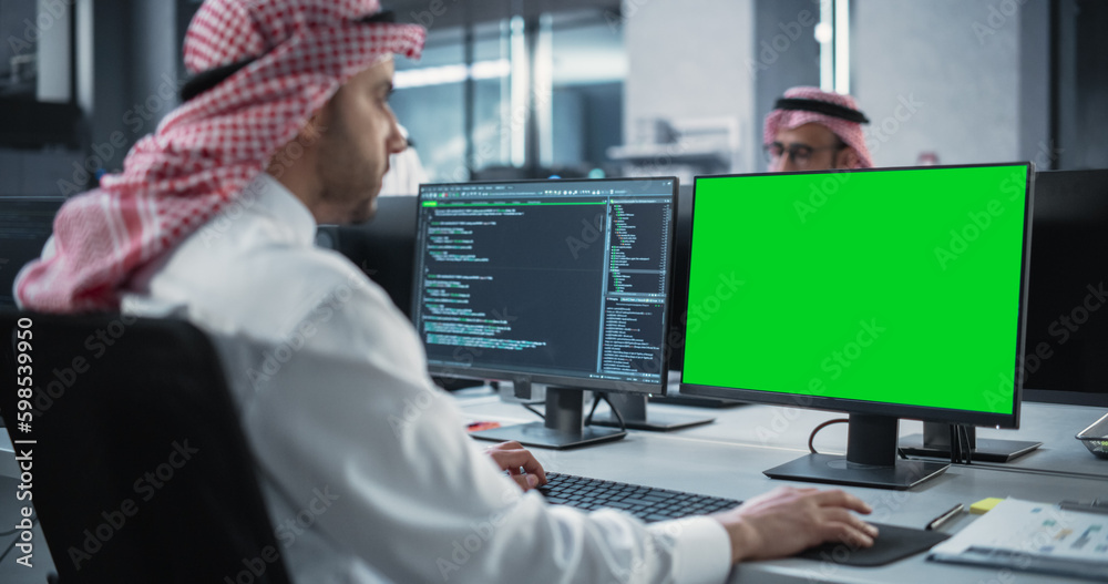 Aufkleber Arab Software Developer Working on Desktop Computer with Green Screen Mock Up Display. Young Middle Eastern Specialist Testing Programming Code for an Innovative Big Data Blockchain Project