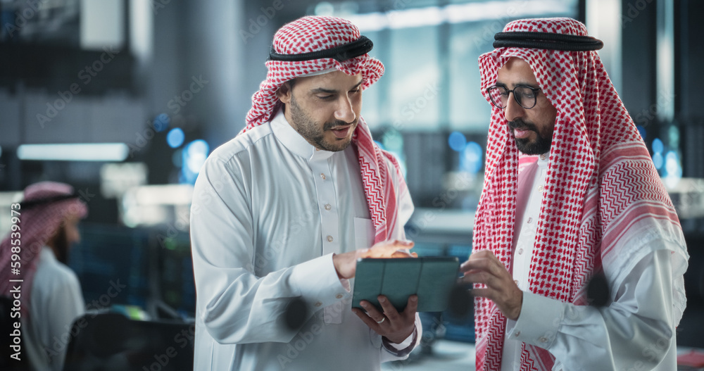 Aufkleber Two Young Muslim Software Engineers Use Tablet Computer to Discuss a Technological Project in a Modern Industrial Office. Arab Scientists Work in Research and Development Center