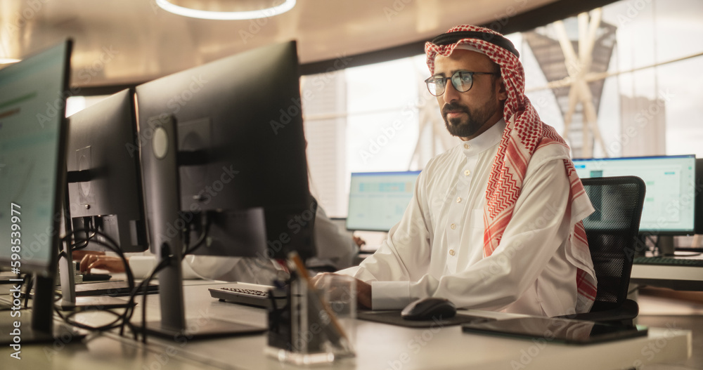 Aufkleber Portrait of a Middle Eastern Engineer Working on Desktop Computer in a Technological Office Environment. Arab Software Developer Researching New Ideas to Problem Solve a Technical Assignment