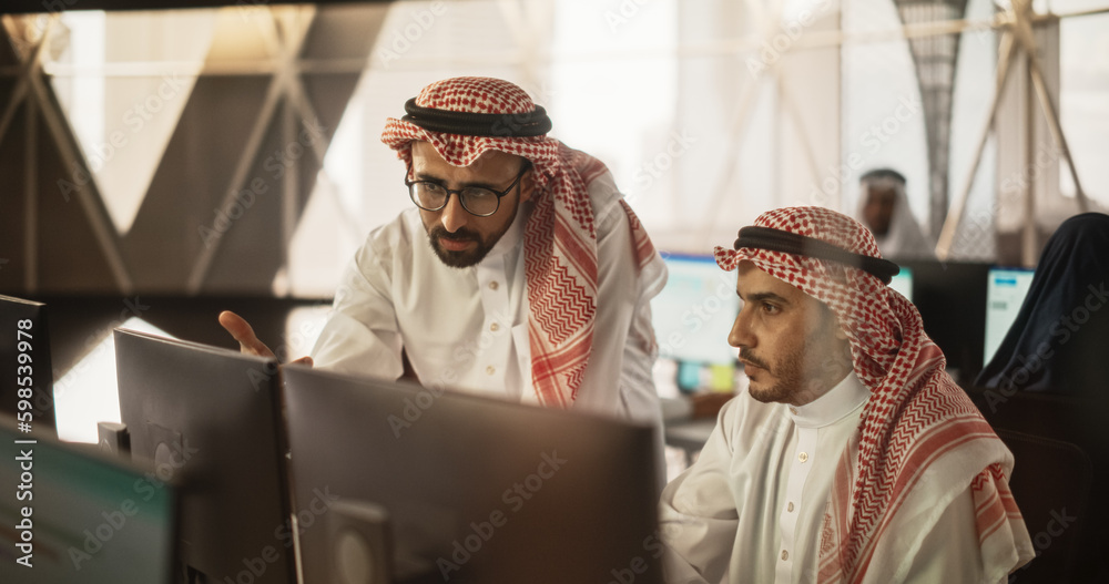 Aufkleber Portrait of a Middle Eastern Engineer Working on Desktop Computer in a Fintech Startup Company. Arab Software Developer Researching New Ideas to Problem Solve a Technical Assignment