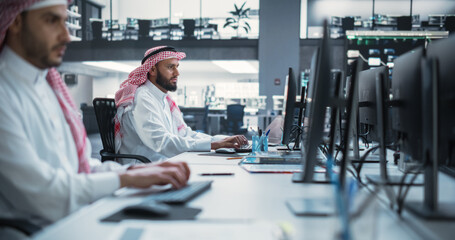 Middle Eastern Engineer Working on Desktop Computer in a Technological Corporate Office. Manager Working with Colleagues on Innovative Internet and Software as a Service Project