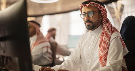 Portrait of a Smart Focused Middle Eastern Programmer Working on Computer in a Technological...