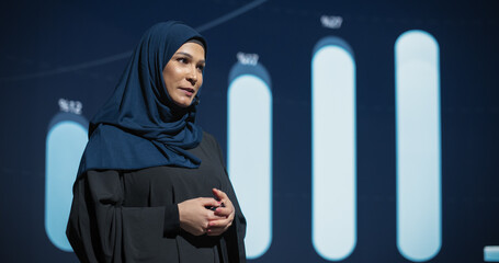 Successful Middle Eastern Female Speaker Presenting a New Product, Showing Infographics, Statistics...
