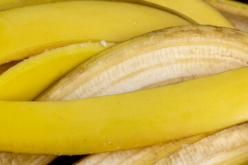 peeled ripe yellow bananas on a wooden board