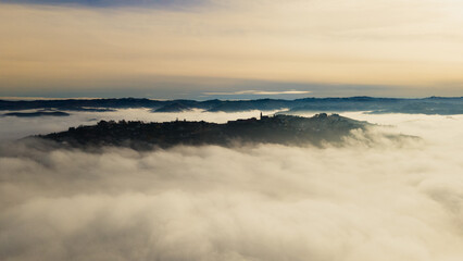 Naklejka na ściany i meble a hill town surrounded by fog, (Diano d'Alba)